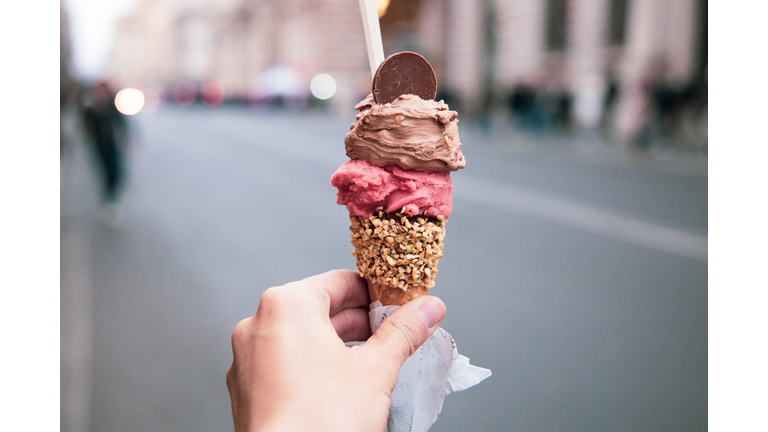 Trying tasty ice cream with levels in Rome during travel vacations.