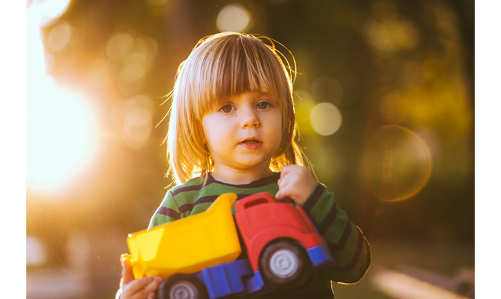 Little Boy Holding Truck Toy in a Park