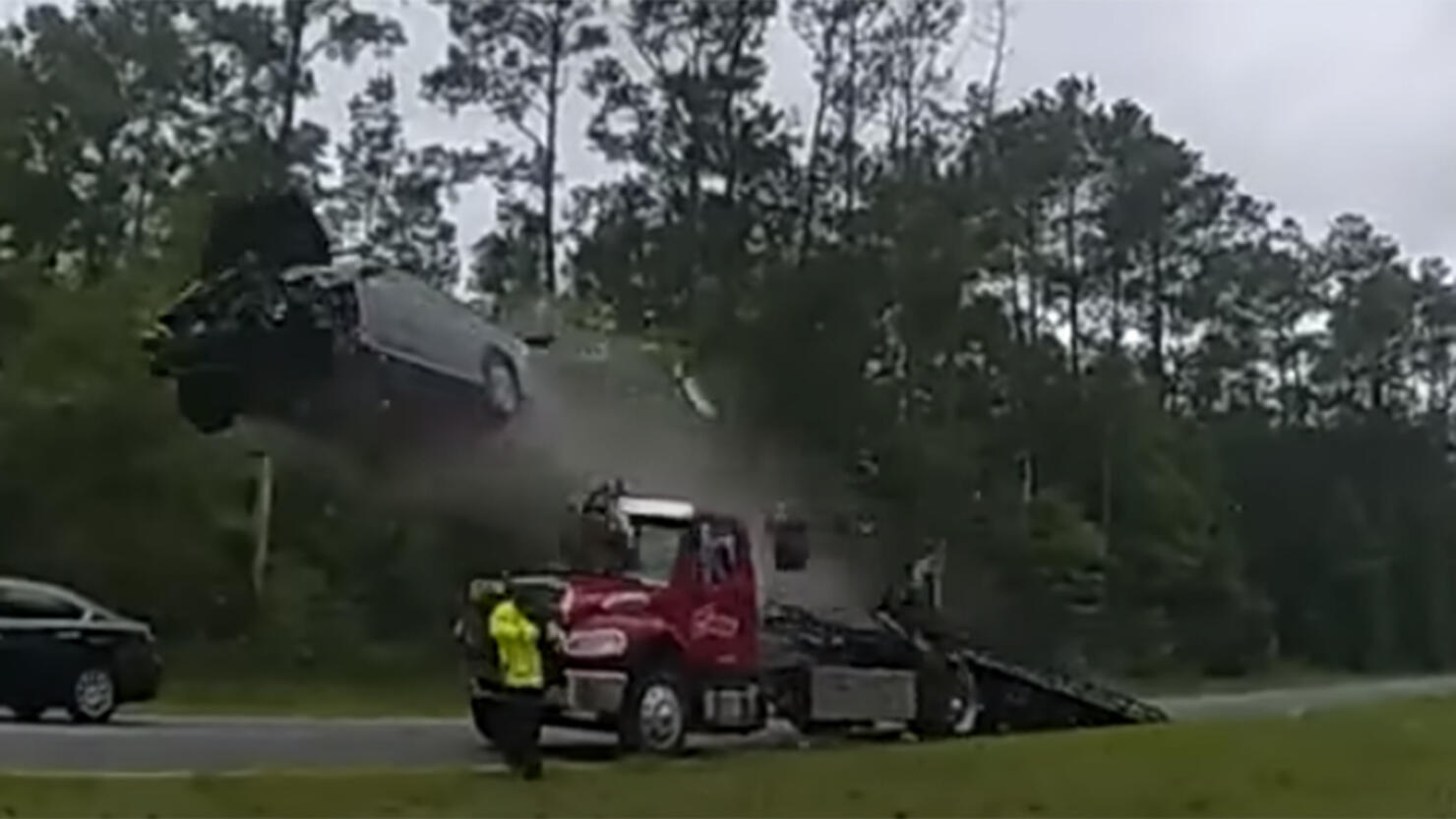 car vaults over tow truck