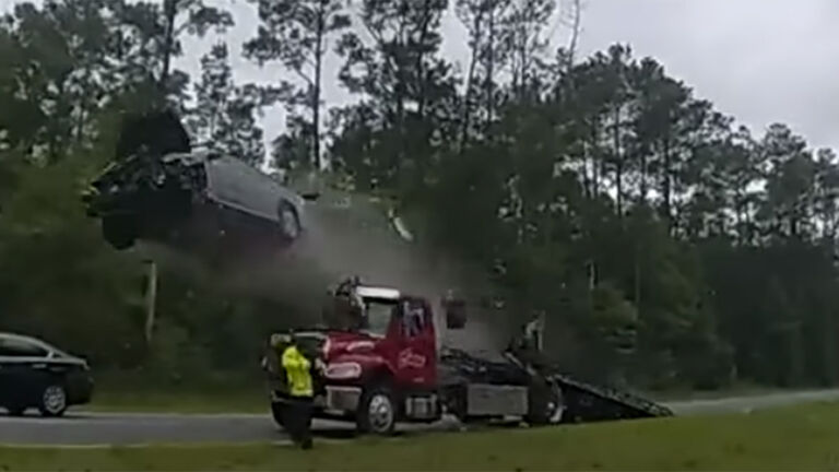 car vaults over tow truck