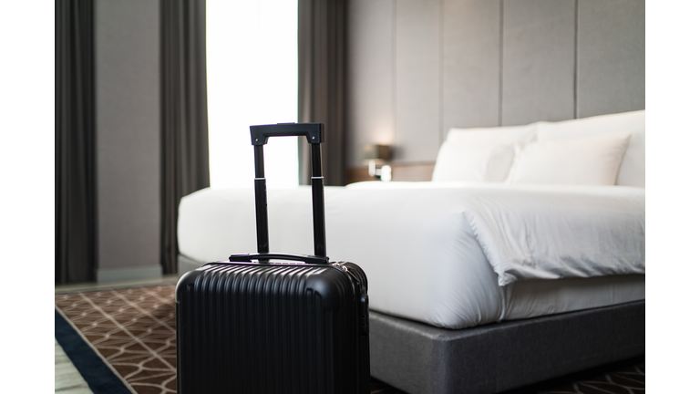 A suitcase placing in front of the bedroom in luxury hotel room