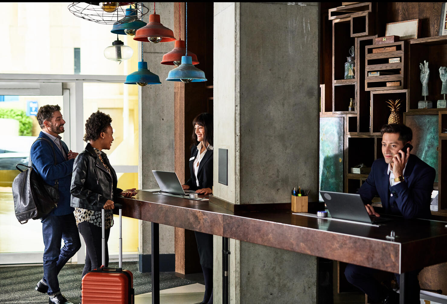 Businessman and woman checking in to hotel reception