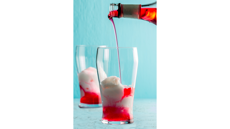 Preparation of cocktail Terremoto. Chilean traditional alcoholic drink Terrremoto. with pineapple ice cream, liquor grenadine, pisco and white wine. Blue background