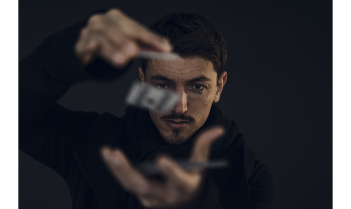 Portrait of magician conjuring with playing cards