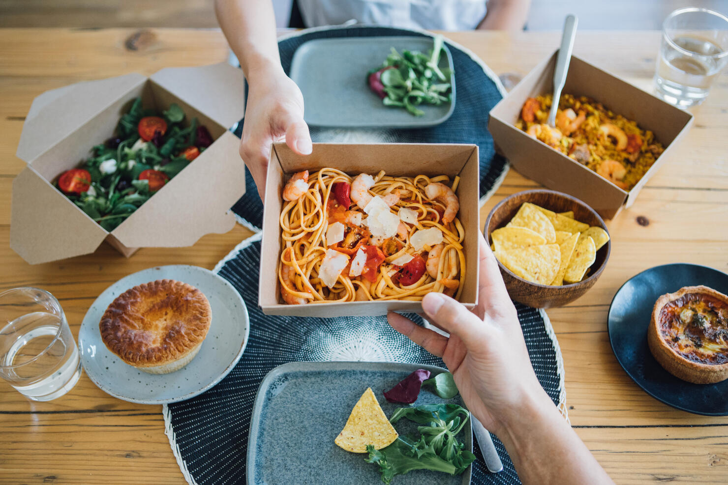 Couple Sharing Takeaway Meal At Dining Table