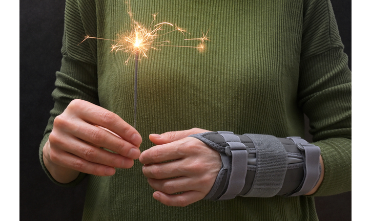 Woman With Sparkler and Contused Hand In Stabilizer