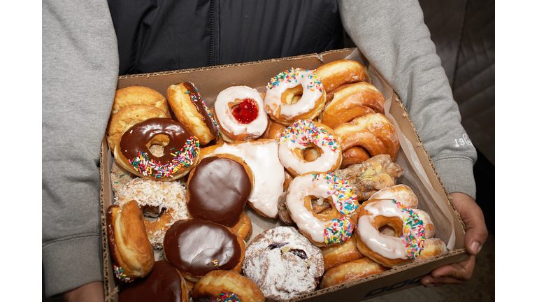 Street vendor carrying box of doughnuts, mid section, elevated view