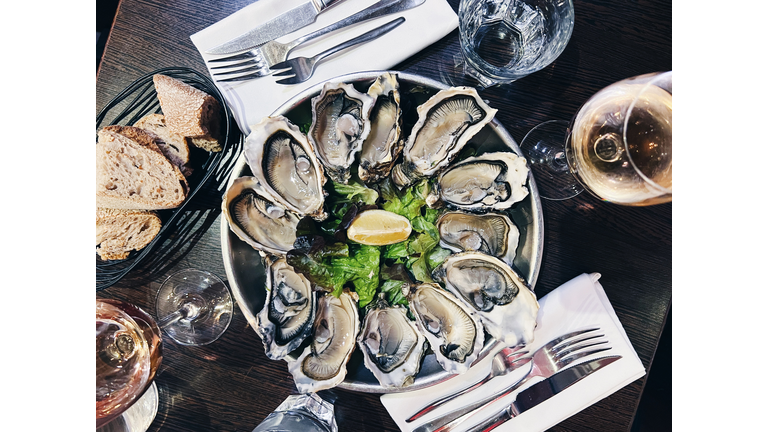 Oysters plate and white wine in a restaurant, directly above view