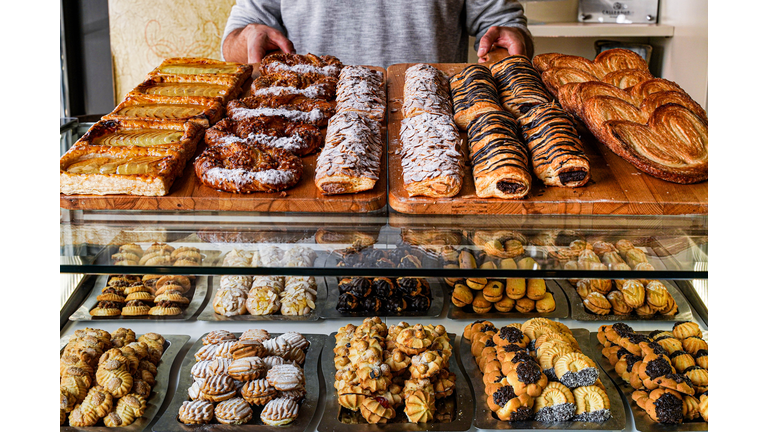 Man dispensing cakes in a pastry bakery