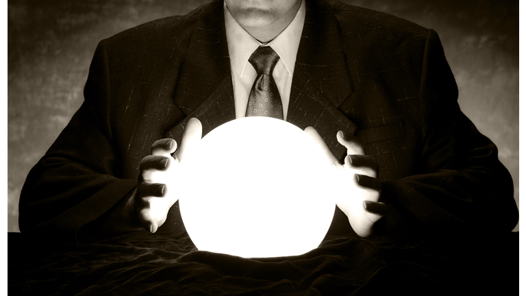 Man in suit holds hands over glowing crystal ball