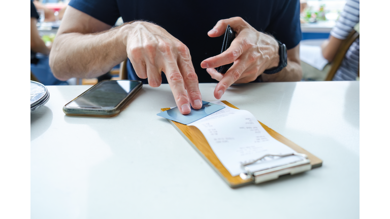 Man Prepares to Pay Restaurant Bill With Credit Card