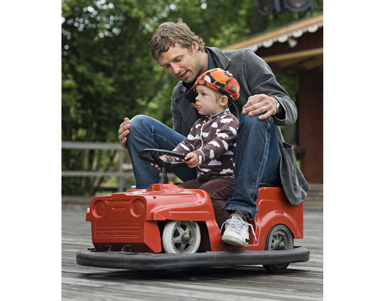 Father and son riding an electric car Skansen Sweden.