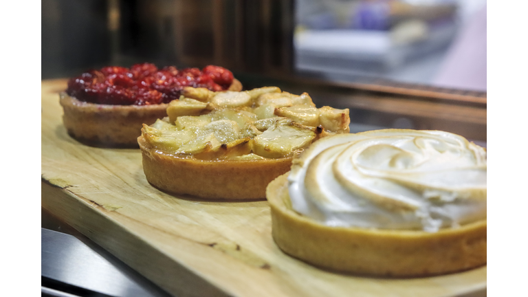 Side view of a fridge display with fruits tarts in a bakery shop
