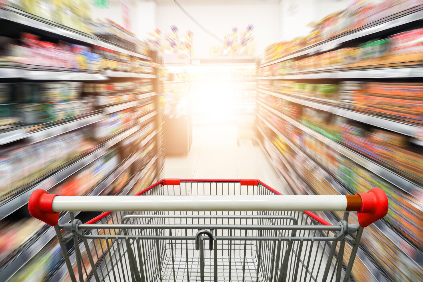 Supermarket aisle with empty red shopping cart