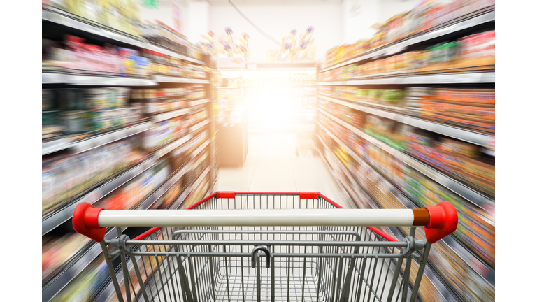 Supermarket aisle with empty red shopping cart