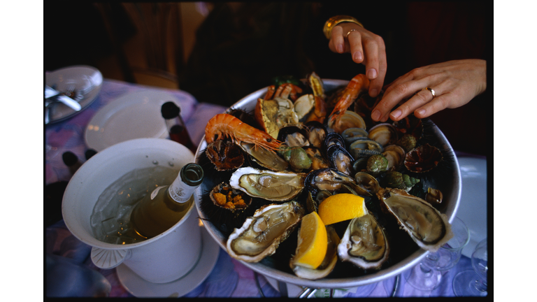 Hands Digging in Seafood Platter