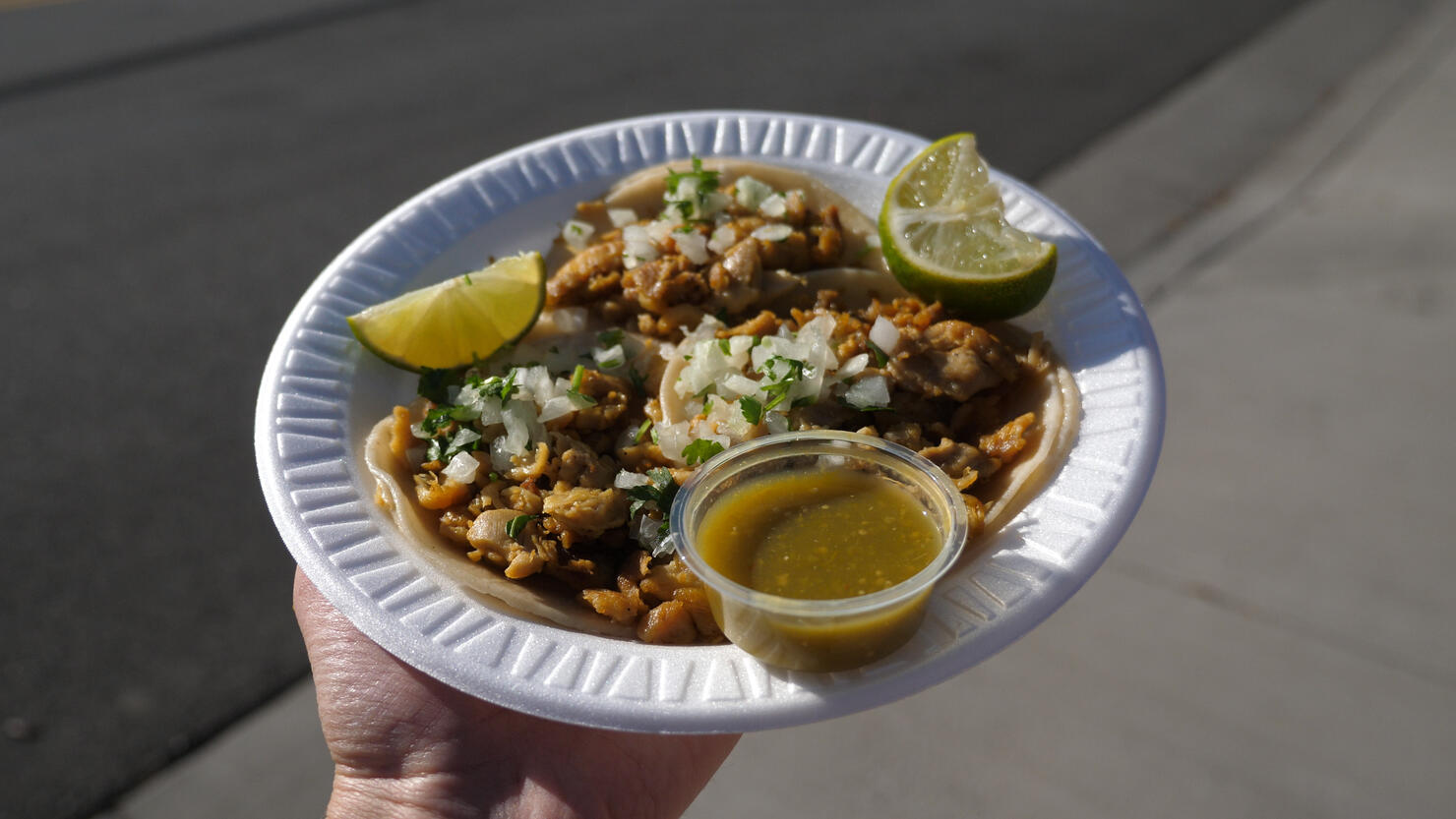 Three Chicken Tacos in hand