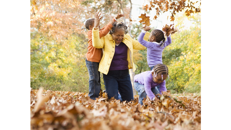 Grandmother and grandsons playing with leaves