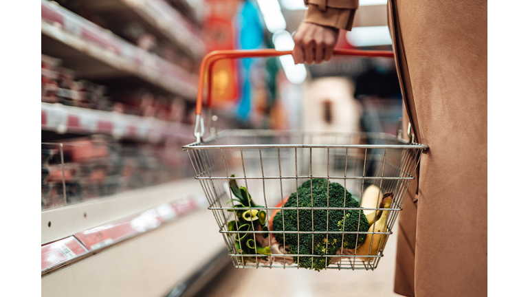 Young woman shopping vegetables in supermarket