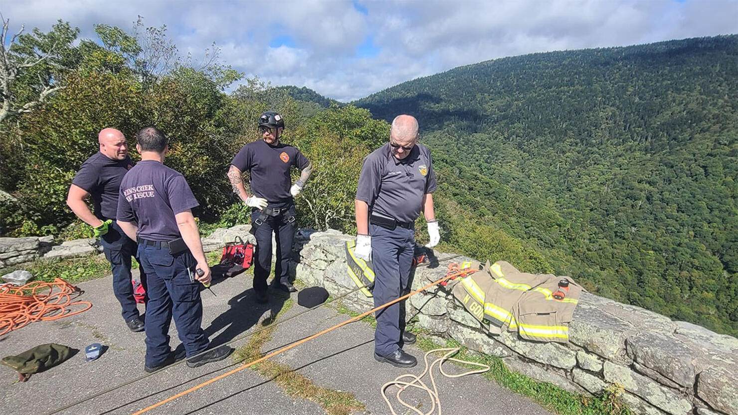 Firefighters rappel down a cliff after a woman fell