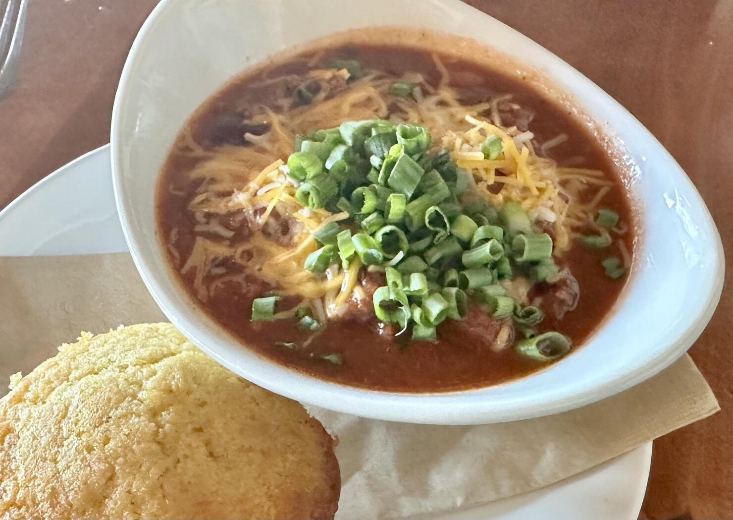Fresh wild game chili and cornbread with onions and beans and cheese