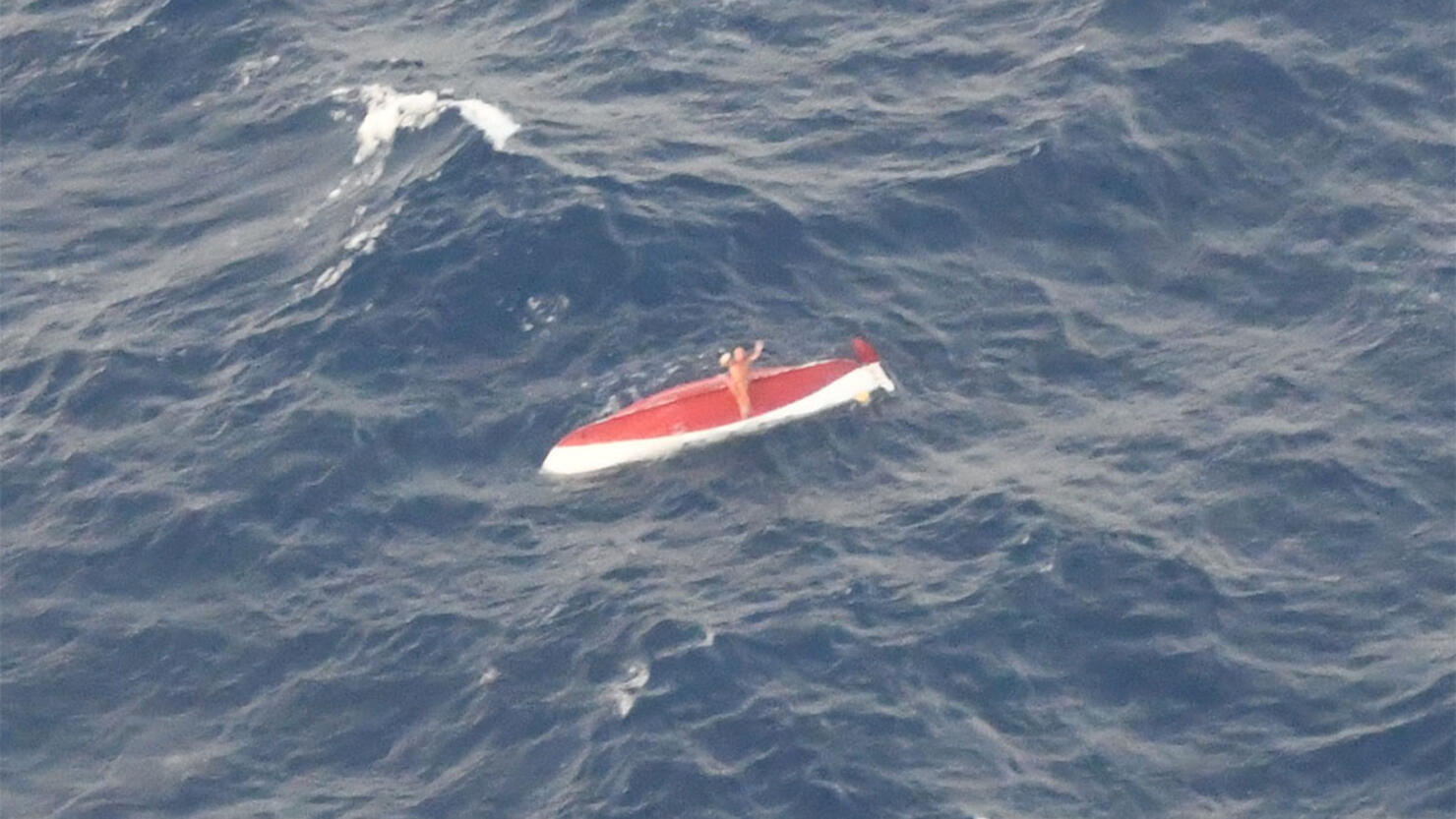 Tom Robinson waits to be rescued after his rowboat capsized