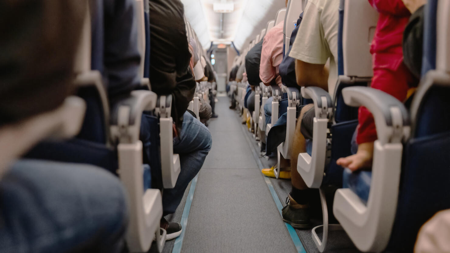Airplane Aisle with View Of People Sitting on Their Seats