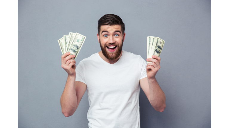 Cheerful man holding dollar bills