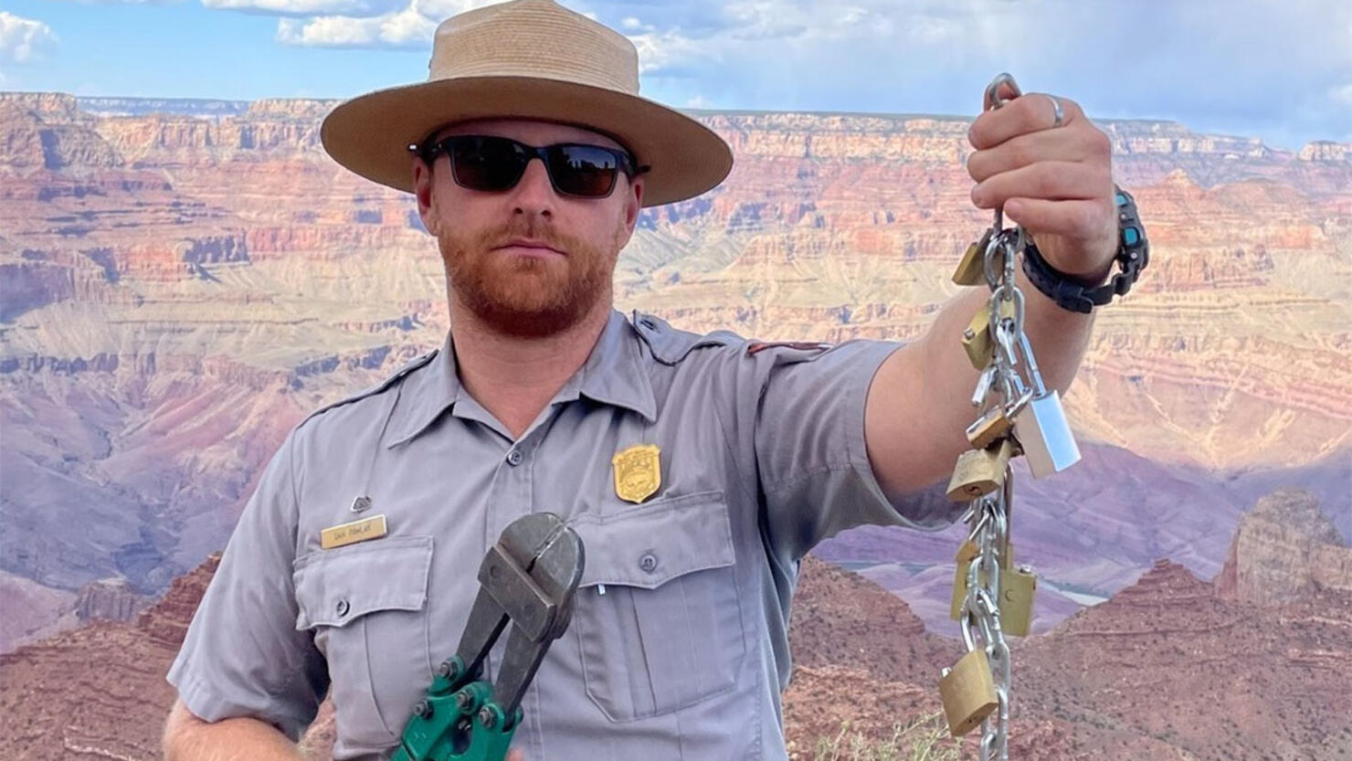 A park ranger holds up "love locks" left behind by visitors at Grand Canyon National Park