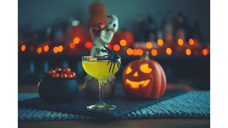 Halloween time. Vibrant colored drinks with cauldron of candy