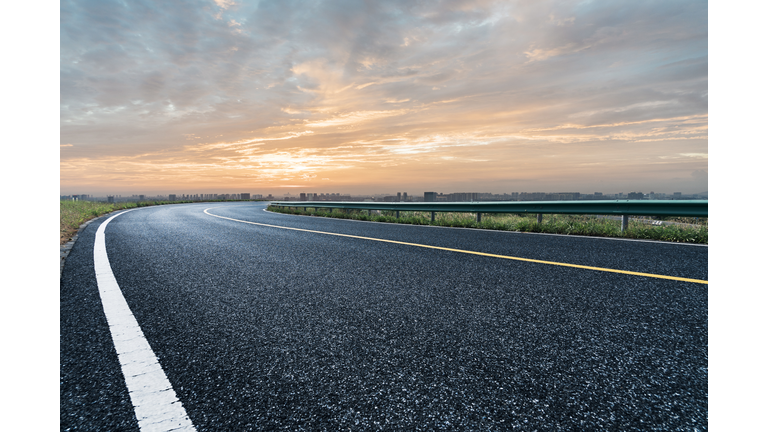 empty tarmac road against sunset sky
