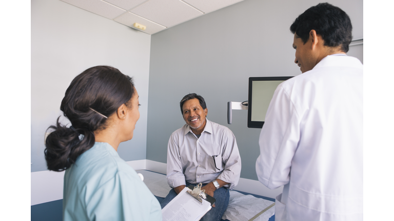 Smiling senior patient talking with doctor and nurse