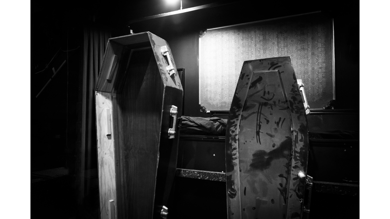 Two dusty coffins leaning against a wall