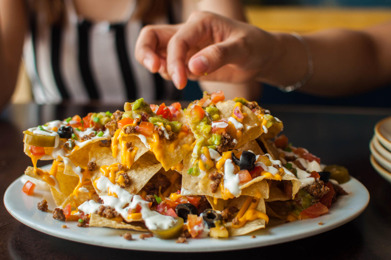 A young woman is eating a freshly made tacos
