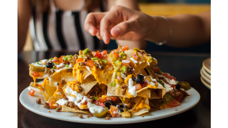 A young woman is eating a freshly made tacos