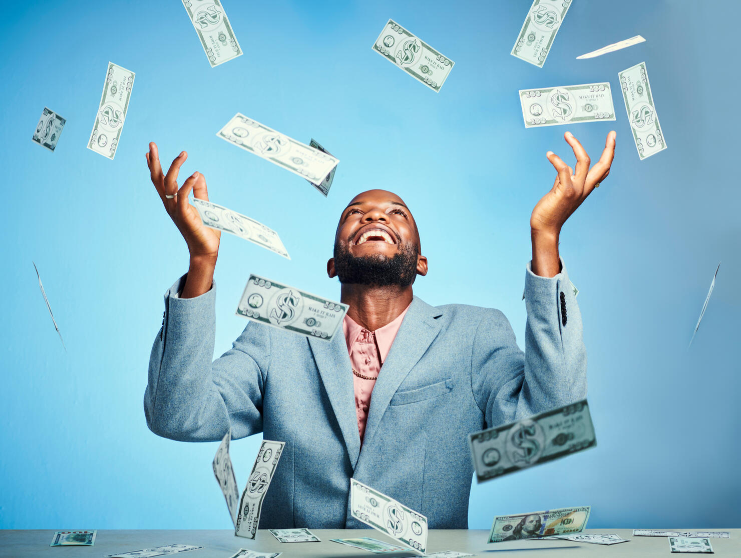 Black man, money winner and success celebration for finance growth, investment and savings budget on blue background in studio. Smile, happy and excited financial worker with stock market trade cash