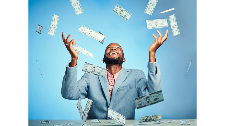 Black man, money winner and success celebration for finance growth, investment and savings budget on blue background in studio. Smile, happy and excited financial worker with stock market trade cash