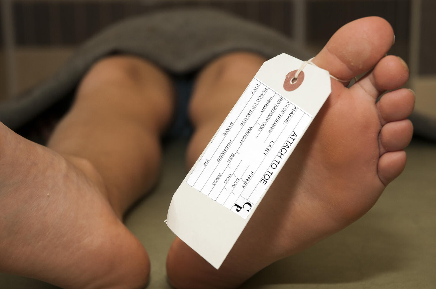 Toe tag tied to a corpse in a mortuary