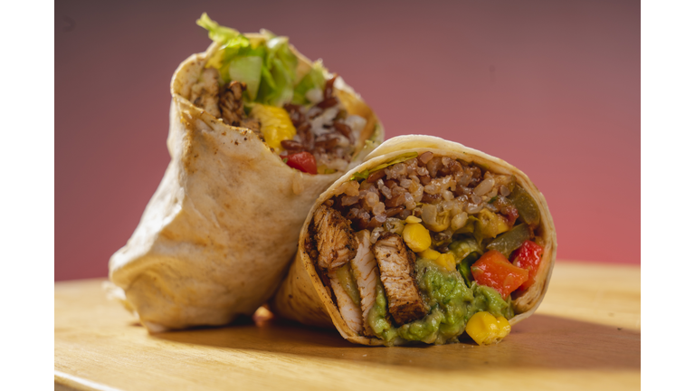 Barbecue chicken, corn and guacamole tortilla wraps on a wooden base. Vegetable burrito. Healthy food.
