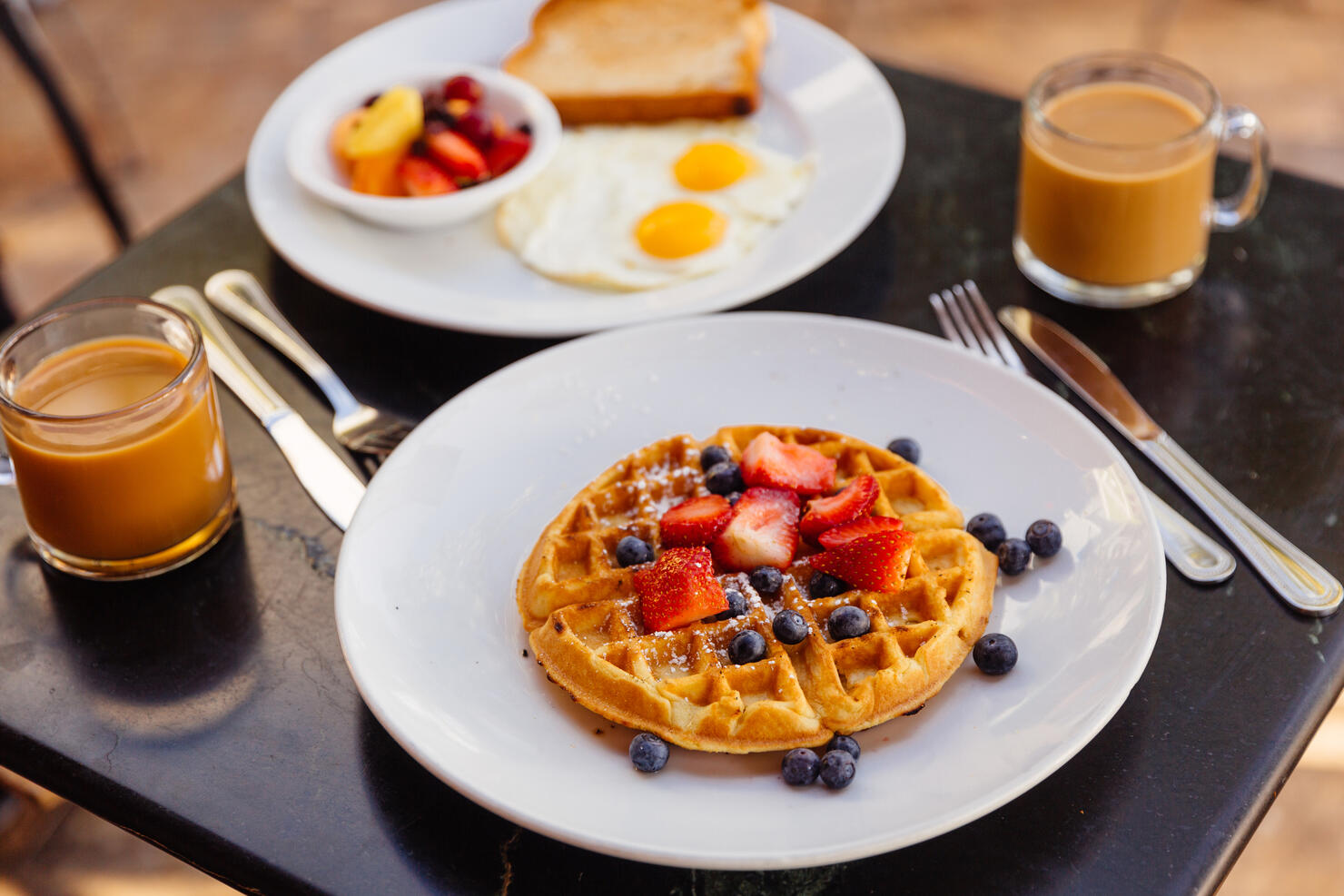 Waffle with strawberries and blueberries served for breakfast in a cafe