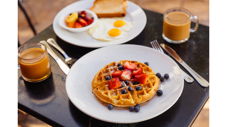 Waffle with strawberries and blueberries served for breakfast in a cafe