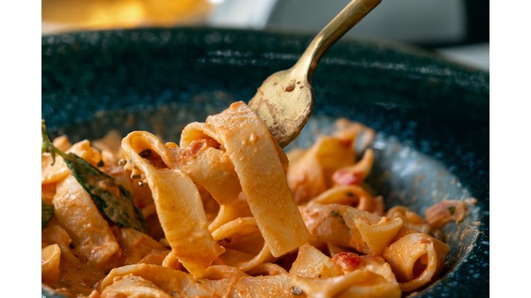 Vegetarian or vegan Italian pasta in tomato sauce. Cooking and serving vegan dishes at home, in a cafe or restaurant. Spaghetti with sliced vegetables, in a beautiful plate, on the dining table. Vegetable food. Sustainable development. Ethical consumption