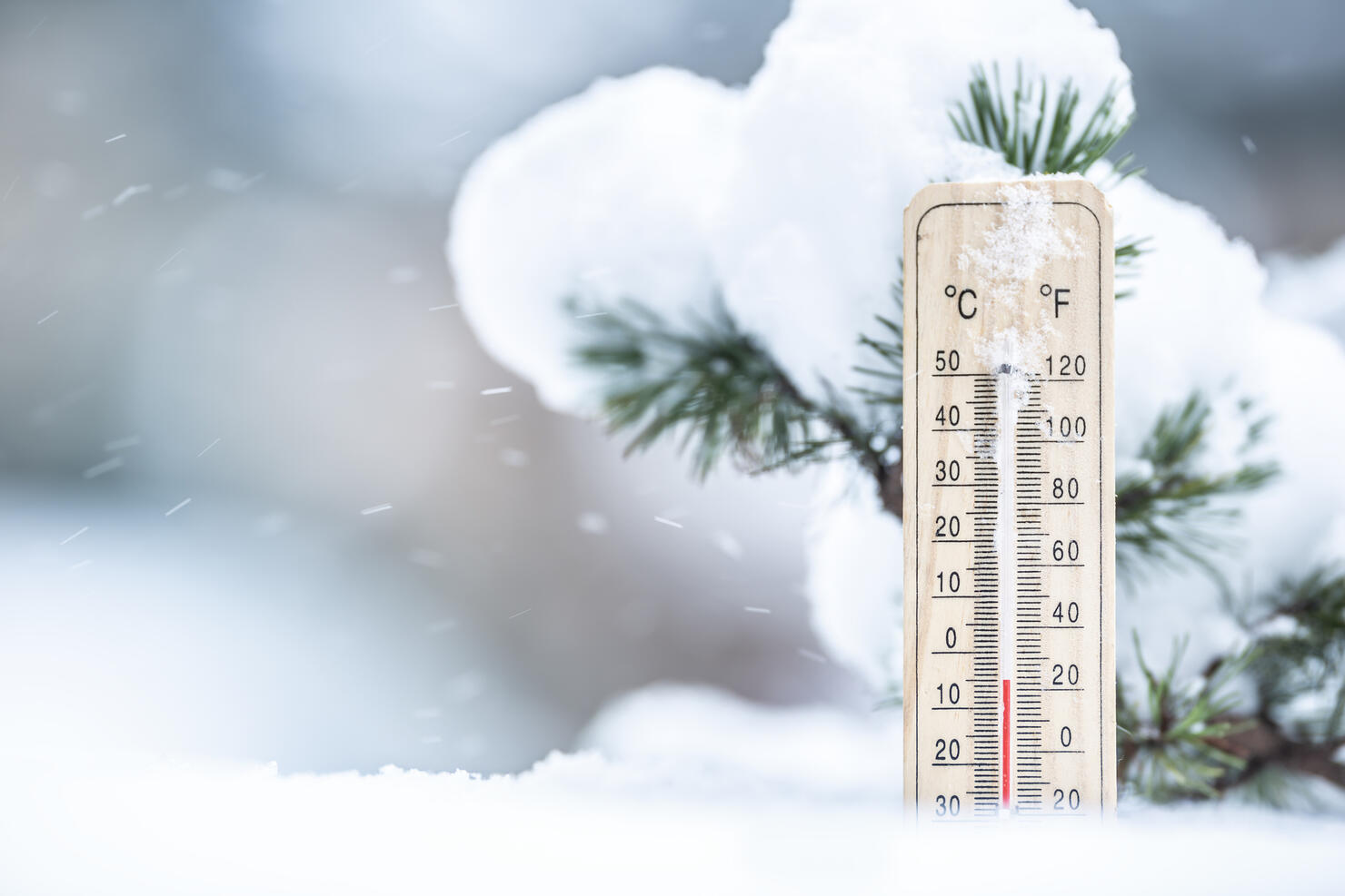 Thermometer in the snow shows low temperatures in Celsius and Farenhaits.