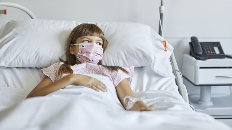 Sick girl lying on bed in ICU during COVID-19