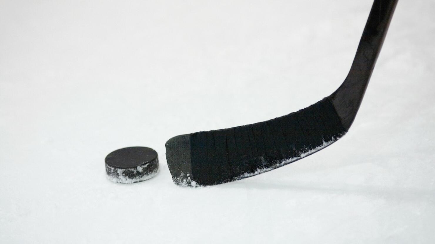 Close-up of an ice hockey stick with a hockey puck