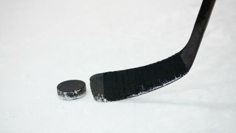 Close-up of an ice hockey stick with a hockey puck