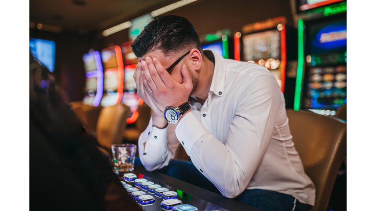 Young man loosing his money on slot machines