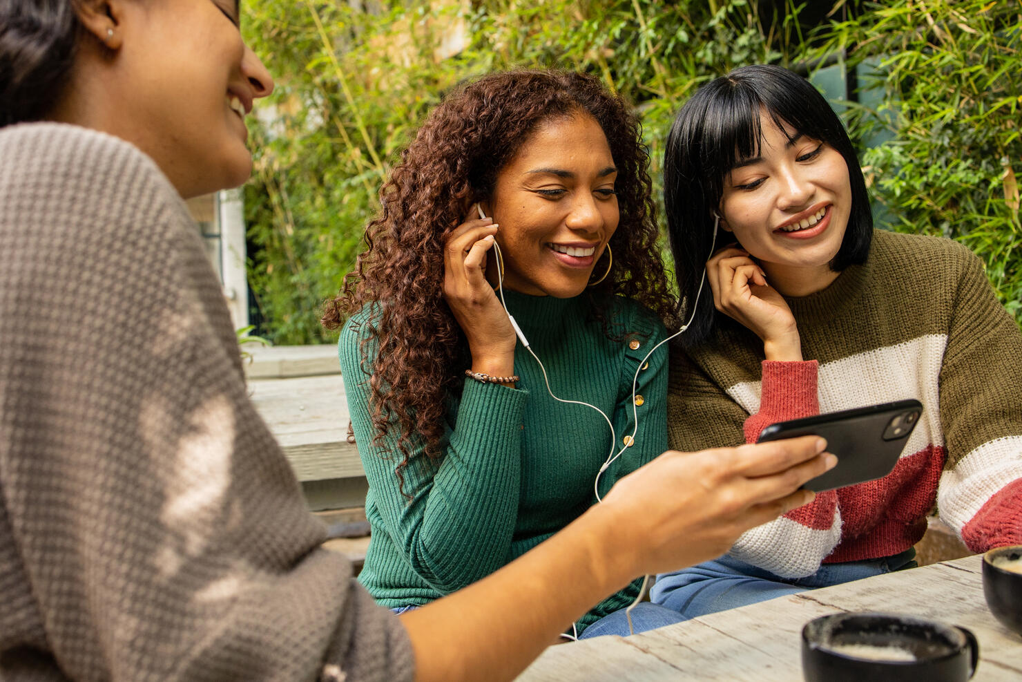 Three friends watching online content on the mobile phone