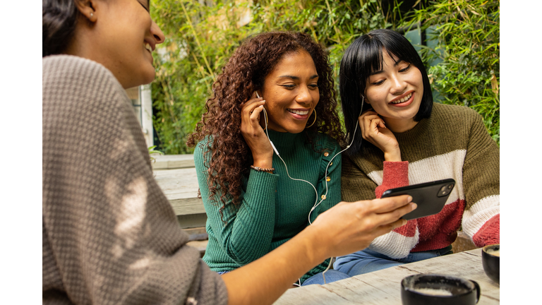 Three friends watching online content on the mobile phone