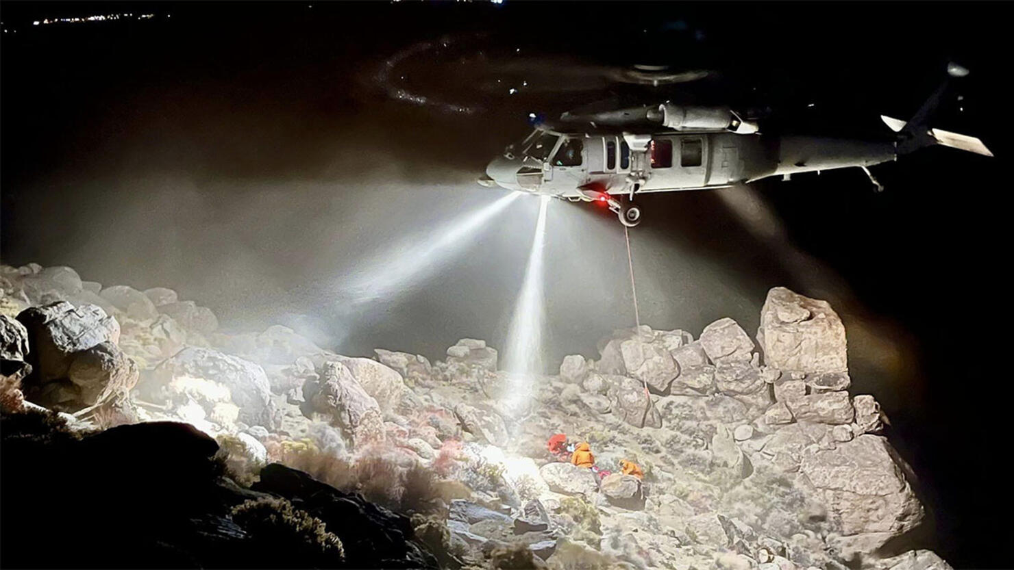 Rescue workers free a hiker trapped under a boulder.